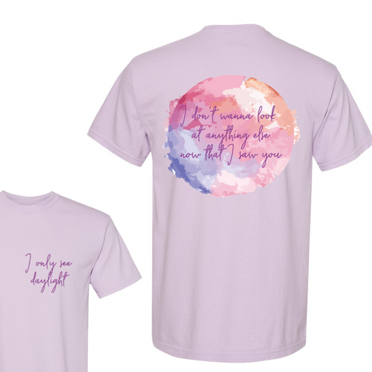 Light purple t-shirt with watercolor design and text on a white background
