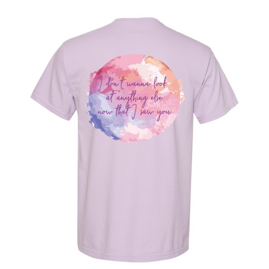 Light purple t-shirt with colorful watercolor design and text on the back against a white background
