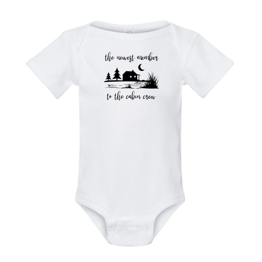 White baby onesie with black cabin-themed design and text on a white background