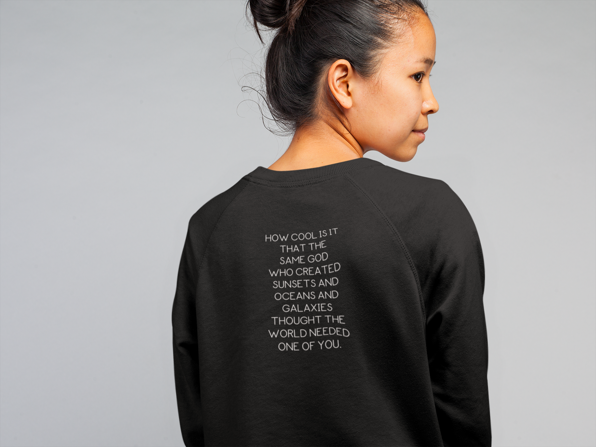 Back view of the sweatshirt in black with the words"How cool is it that the same god who created sunsets and oceans and galaxies thought the world needed one of you" written on it.