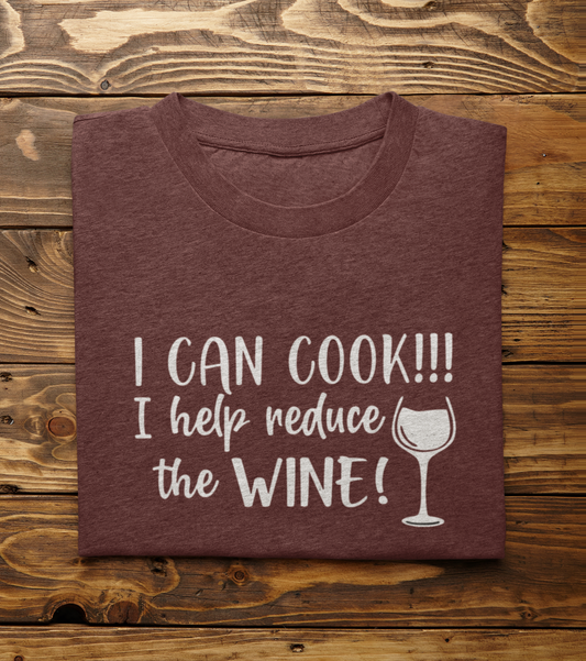 I Can Cook T-Shirt in maroon folded on a brown wooden background