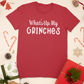 What's Up My Grinches? - T-Shirt laid out In a stylized setting