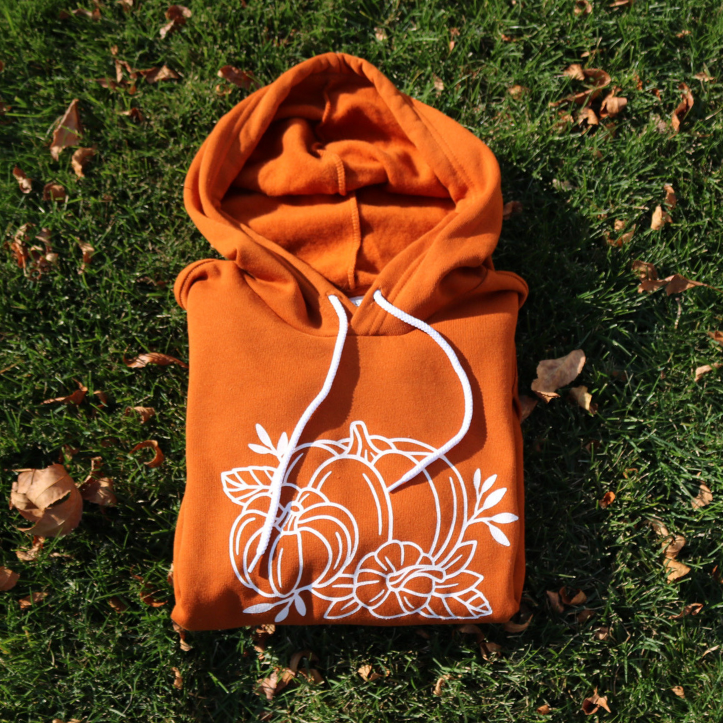 Fall Pumpkin - Hoodie folded laying on grass
