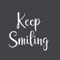 Not Everything That Weighs You Down - Pull Over Sweatshirt in charcoal gray. The back has a white cursive saying of "not everything that weighs you down is yours to carry" with the front corner pocket saying in a cursive font in white of "keep smiling". This is an up close image of the keep smiling design on gray.