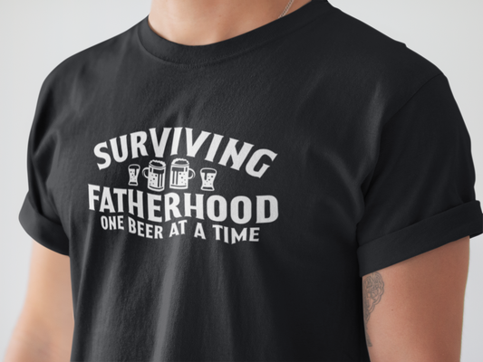 Surviving Fatherhood One Beer At A Time - Black T-Shirt - front view in white writing. Between the word surviving and fatherhood is different glasses of beer mugs. This is the front view of the shirt up close on a model.