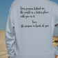 Dear Person Behind Me - Pull Over Sweatshirt in light blue. Designs are in black. The back says "Dear person behind me, the world is a better place with you in it. Love the person in front of you" in a cursive design. The front design is on the right hand side, as a small pocket square with the saying "be kind to your mind" in cursive with a heart and semi colon surrounding it. This is the back view of the sweatshirt on a model in an outdoor setting.
