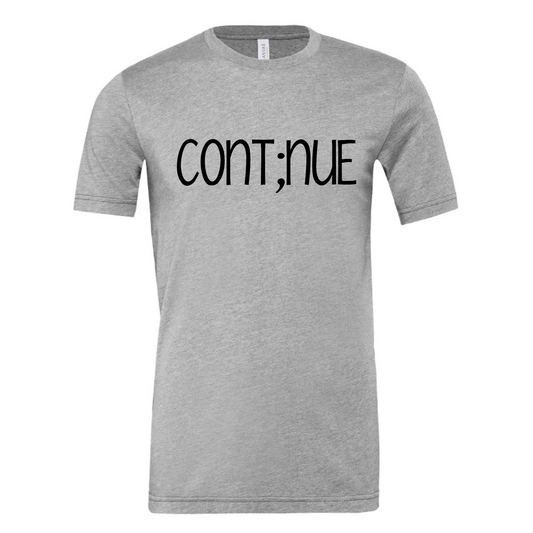Cont;nue - meaning "my story isn't over". You're the author of your story. Don't end it with a period when you feel stuck. Pause, take it in and continue on. Shirt is in a light gray with black writing. This is the front view of the shirt.