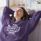 We Almost Always Almost Win Vikings Football Hooded Sweatshirt in purple with white writing. This is the front view of the sweatshirt on a model. She is sitting on a couch with her hands and arms back behind her head, closing her eyes in disappointment.
