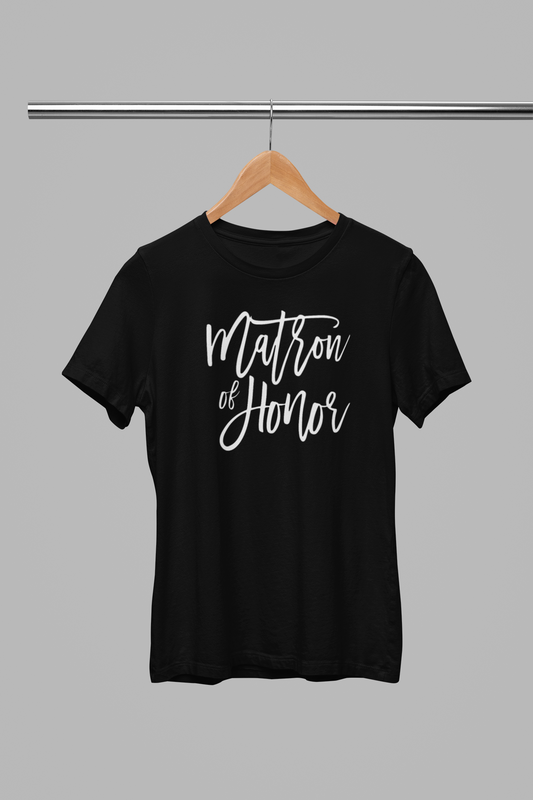Matron of Honor T-Shirt in black with white script font writing on the front. This is the front view of the shirt hanging on a wooden hanger, hanging on a metal clothing rack.