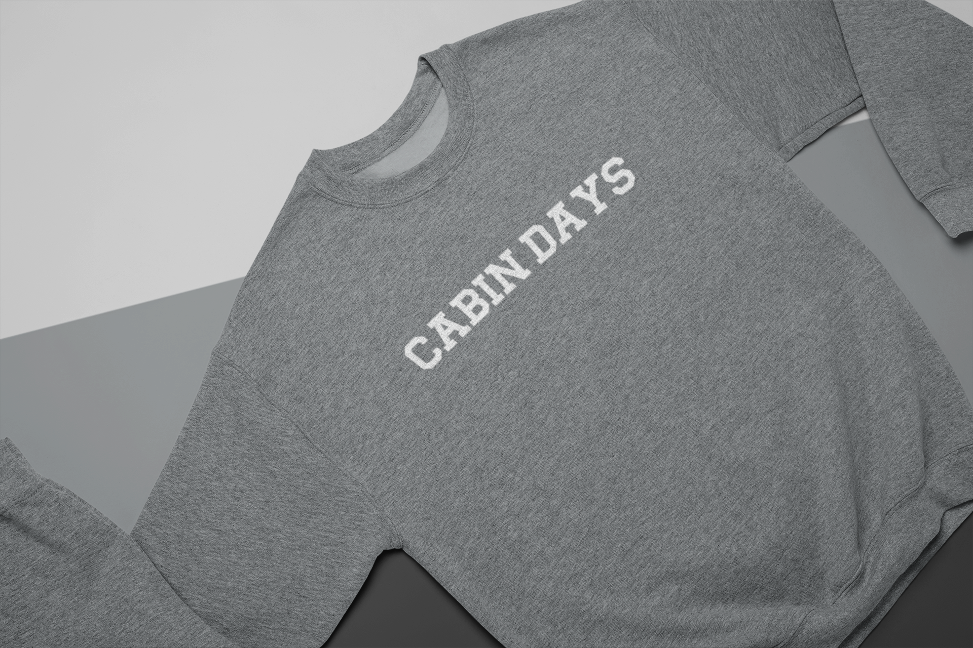 Cabin Days Sweatshirt Laid out Sweatshirt on a 3-toned background.