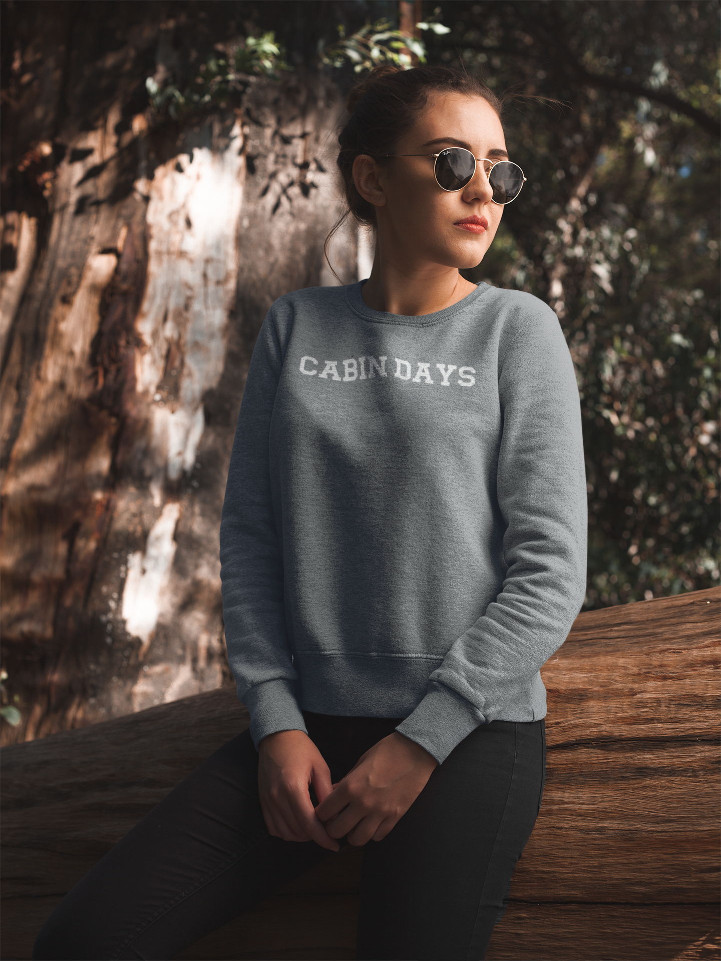 Cabin Days Sweatshirt on a model in a woodsy area.
