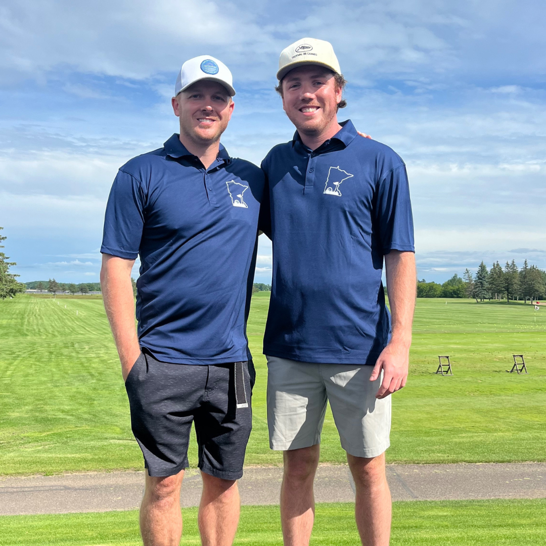 Minnesota Golf Short Sleeve Polo on two male models on a golf course posing and smiling