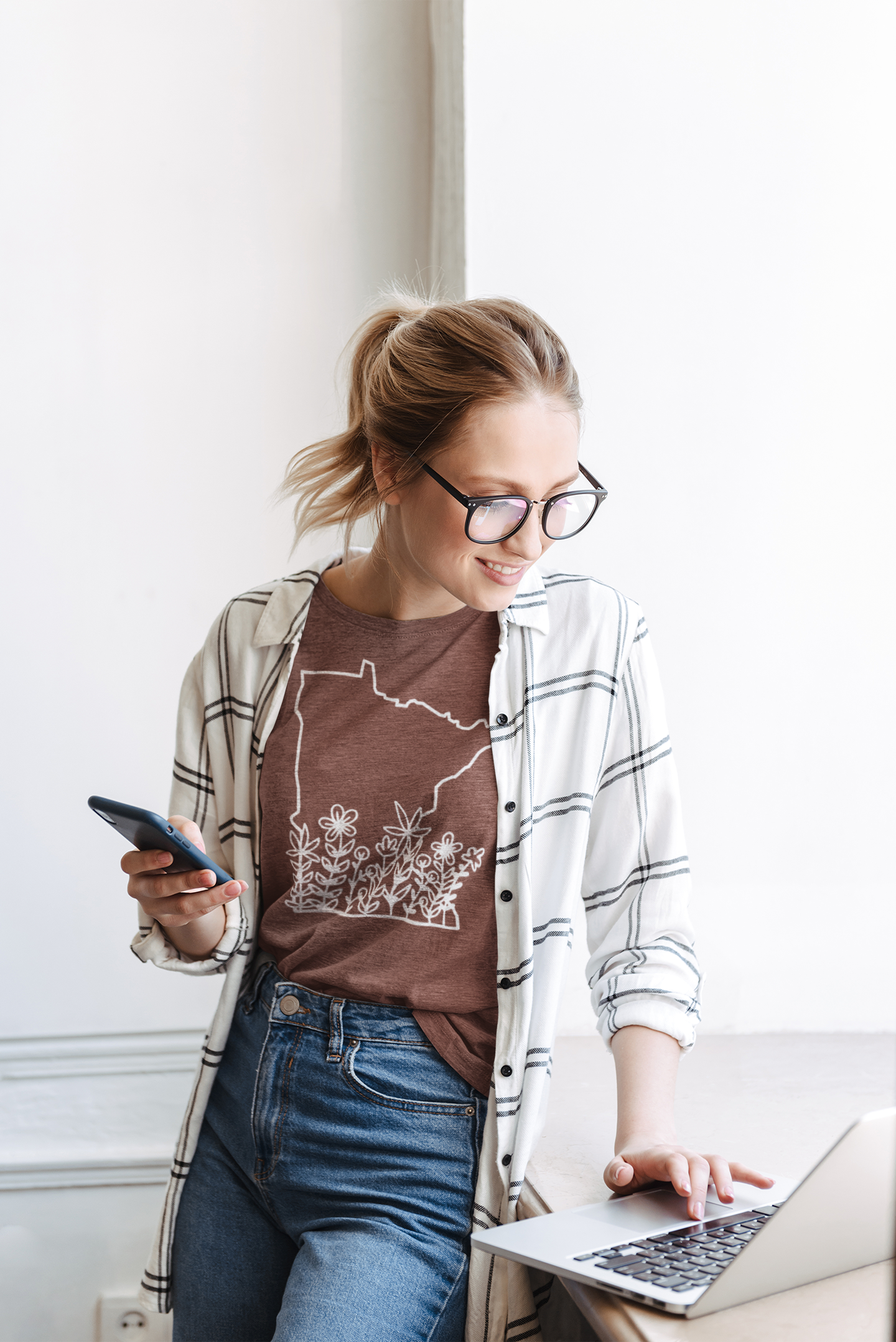 State of Minnesota Flowers Design T-shirt on a model looking at computer with a white and black plaid blazer